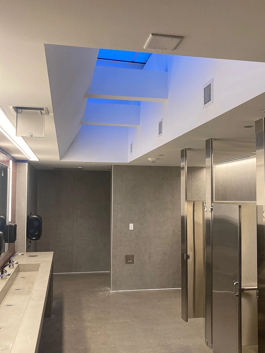 Commercial interior build-out in Central Texas featuring specialized drywall finishes, recessed lighting, and industrial restroom partitions for institutional facilities